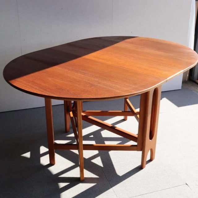 Mid-century British Jentique vintage teak drop-leaf table with oval top and slender rounded legs, Danish design influence.