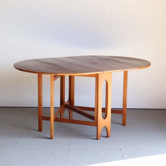 Mid-century vintage teak drop-leaf dining table by JENTIQUE with rounded top and sculpted legs from British-Danish design.