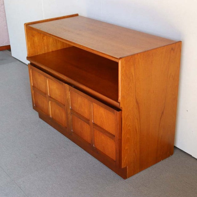 Mid-century British Nathan teak storage cabinet with cross-design drawer fronts and open shelf, rich wood grain, solid wood.