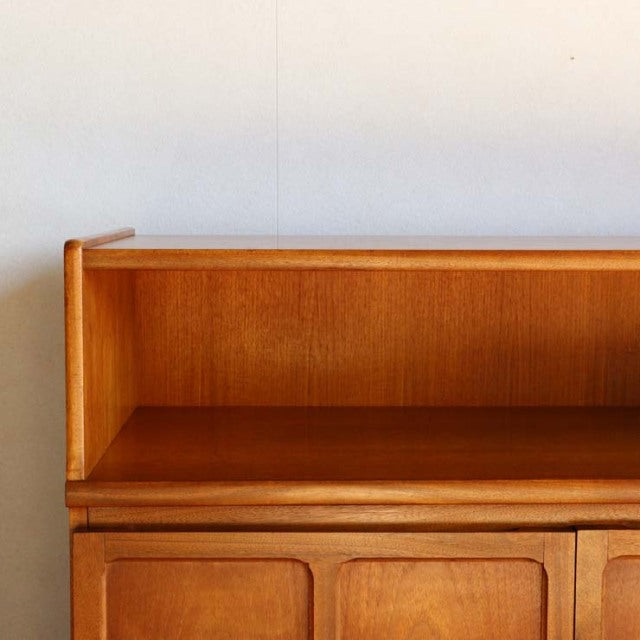 Mid-century vintage teak storage cabinet by Nathan featuring British-Denmark design, visible wood grain and rounded corners.