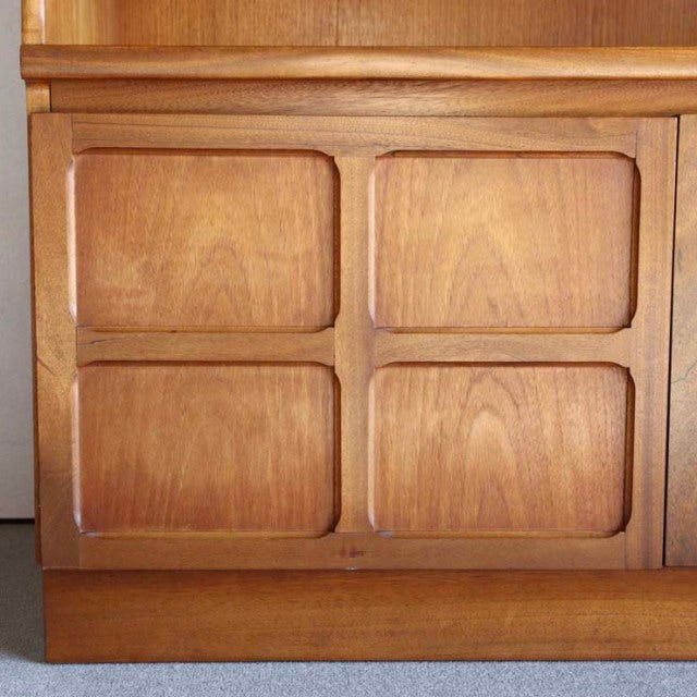 Mid-century British vintage teak storage cabinet by NATHAN with cross-design paneling and smooth wood grain finish.