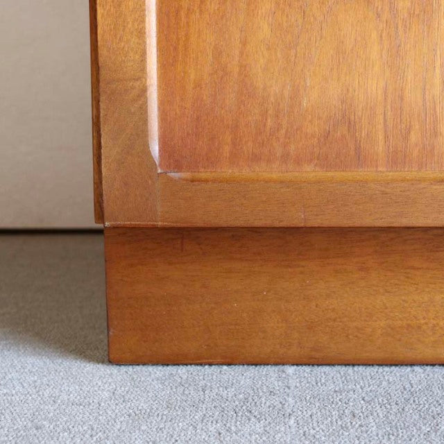 Close-up of vintage mid-century British teak cabinet base with warm wood grain and clean edges.