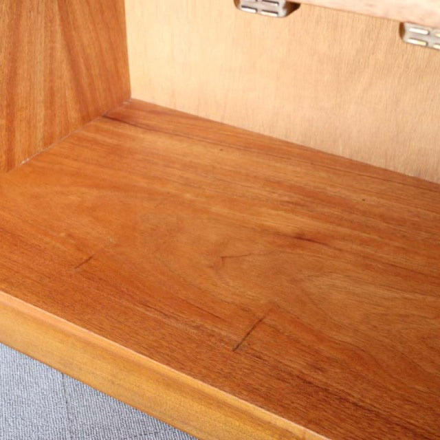 Close-up of vintage mid-century teak wood grain inside British NATHAN storage cabinet with warm honey tones and smooth finish.