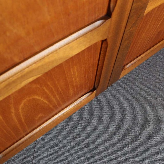 Close-up of vintage mid-century British teak cabinet showing rich wood grain, smooth finish, and clean-lined edges with.
