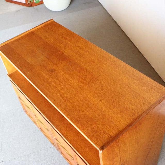 Vintage mid-century teak storage cabinet by Nathan featuring smooth wood grain, clean lines, and tapered legs in.