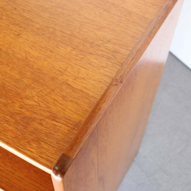 Close-up of vintage teak storage cabinet corner showing rich wood grain and smooth mid-century Danish craftsmanship from.