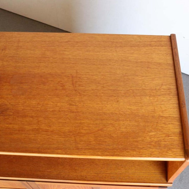 Mid-century British teak cabinet top showing smooth wood grain and warm honey tones with clean Scandinavian-inspired lines.