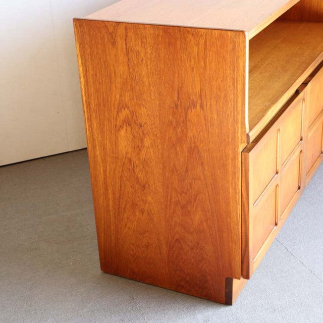 Mid-century British teak storage cabinet by Nathan with cross-design drawer fronts and tapered legs in vintage Danish style.