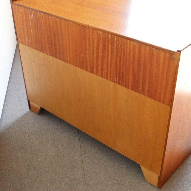Mid-century British teak storage cabinet by Nathan with rich wood grain, cross design, and tapered legs.