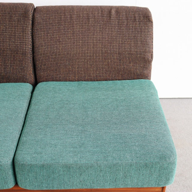 Vintage British mid-century two-seater sofa with teak frame, textured brown backrest, and turquoise Harris Tweed seat.