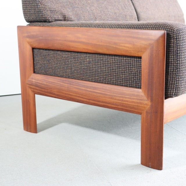 Mid-century teak vintage sofa leg and frame with visible wood grain and Harris Tweed fabric panel.
