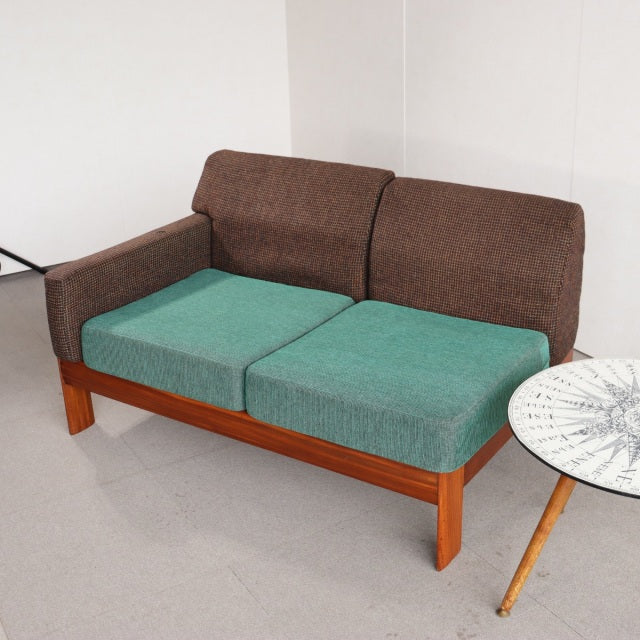 Vintage mid-century teak sofa from British Denmark design, featuring clean lines, sturdy wooden legs, and newly upholstered.