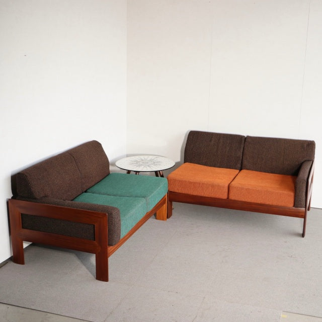Mid-century British vintage teak two-seater sofa set with green and orange upholstery, clean lines, and exposed wood grain.