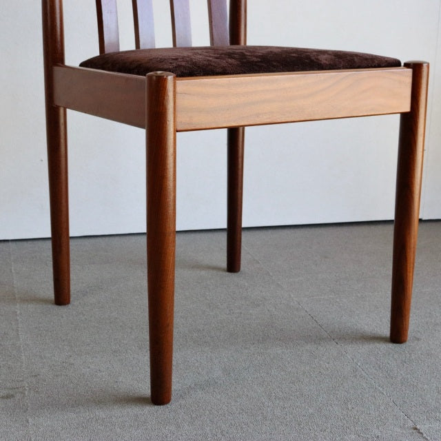 Vintage mid-century Meredew dining chair in teak from Denmark, featuring rich wood grain, slender tapered legs, and a brown.