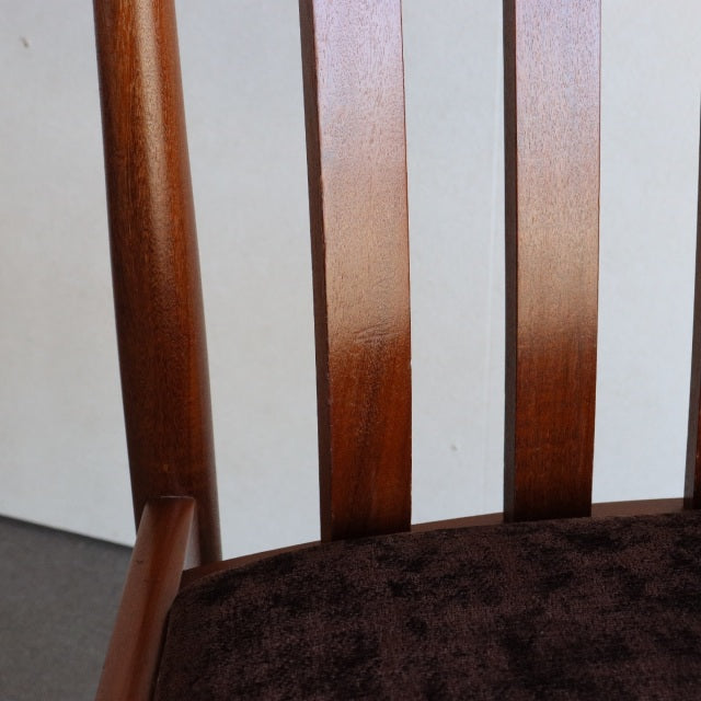 Mid-century British Meredew teak dining chair backrest with vertical slats and dark upholstered seat.