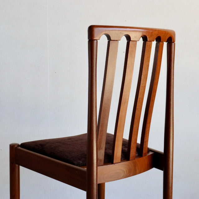 Mid-century British Meredew dining chair in vintage teak with vertical slat back and dark cushioned seat.
