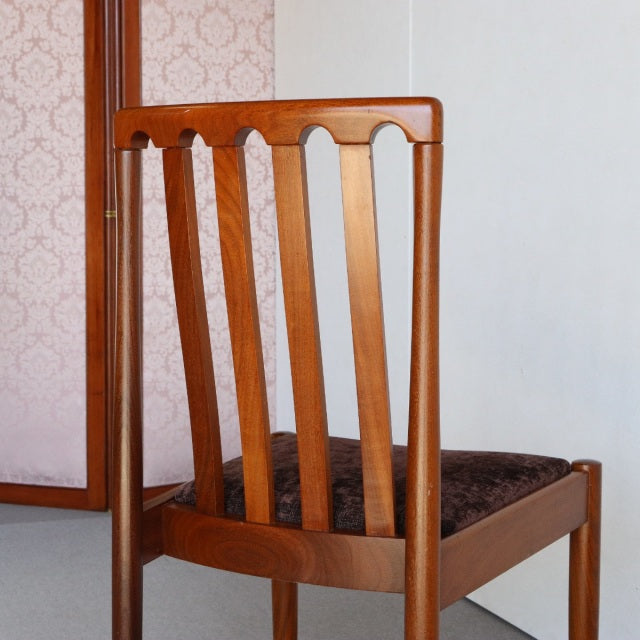 Vintage Meredew teak dining chair with British mid-century design, vertical slat backrest, and dark upholstered seat,.