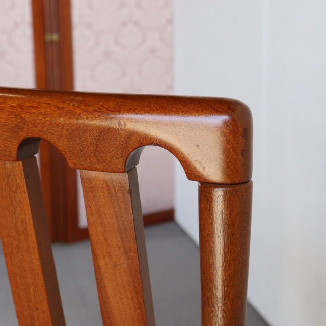 Close-up of vintage Meredew teak dining chair armrest showcasing smooth wood grain and mid-century British design from.