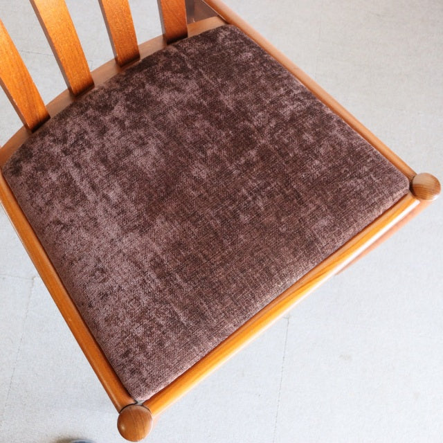 Mid-century British Meredew teak dining chair with slatted back and brown textured fabric seat cushion.