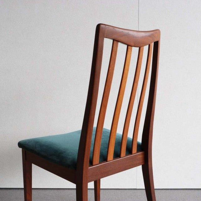 Mid-century British G-Plan dining chair in teak with vertical slatted back and teal upholstered seat, vintage wood grain.