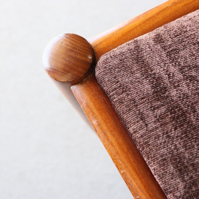 Close-up of vintage teak dining chair corner by Meredew, British mid-century design with rounded wood details and brown.