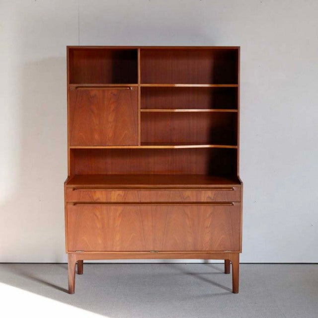 Vintage teak mid-century British Macintosh cabinet with rich wood grain, open shelves, and tapered legs.