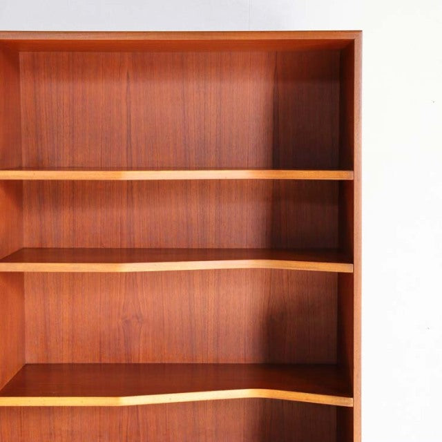 Vintage teak mid-century British Macintosh cabinet with open shelving and smooth wood grain finish.