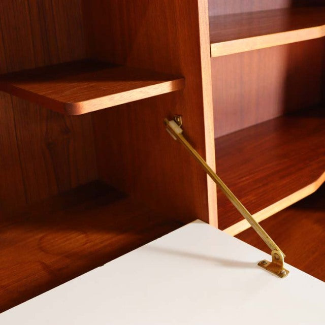 Mid-century British teak cabinet by A.H. McIntosh with visible wood grain and brass support arm.