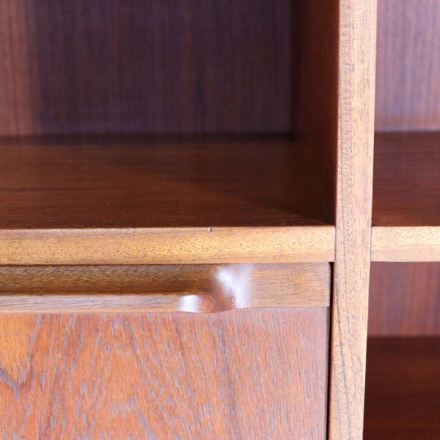 Close-up of vintage British mid-century teak cabinet corner by A.H. McIntosh showing smooth wood grain and rounded edge.