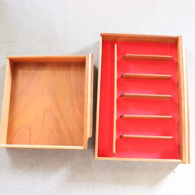 Vintage mid-century British teak cabinet drawer with rich wood grain and red interior trays from Macintosh.