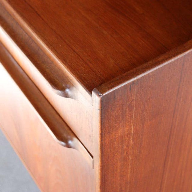 Mid-century British vintage teak cabinet corner showing rich wood grain and smooth rounded drawer edges by A.H. McIntosh.