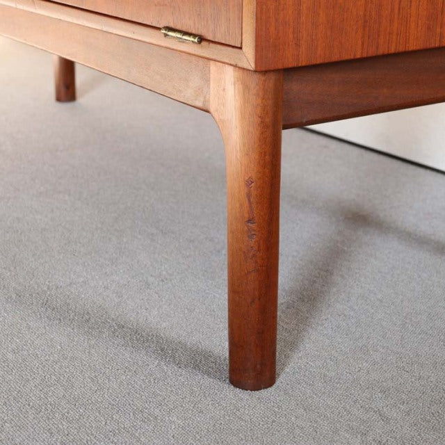 Close-up of vintage teak cabinet leg with smooth grain, mid-century British design by Macintosh.