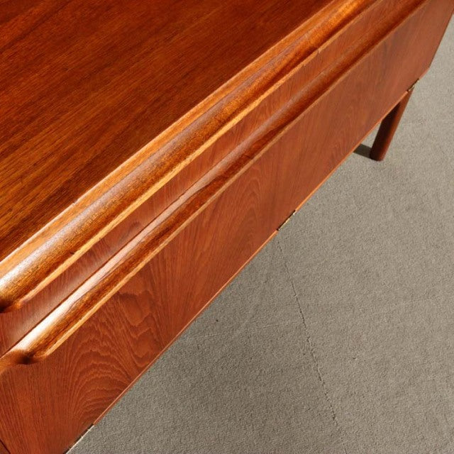 Vintage teak mid-century British Macintosh cabinet corner with smooth wood grain and tapered legs.
