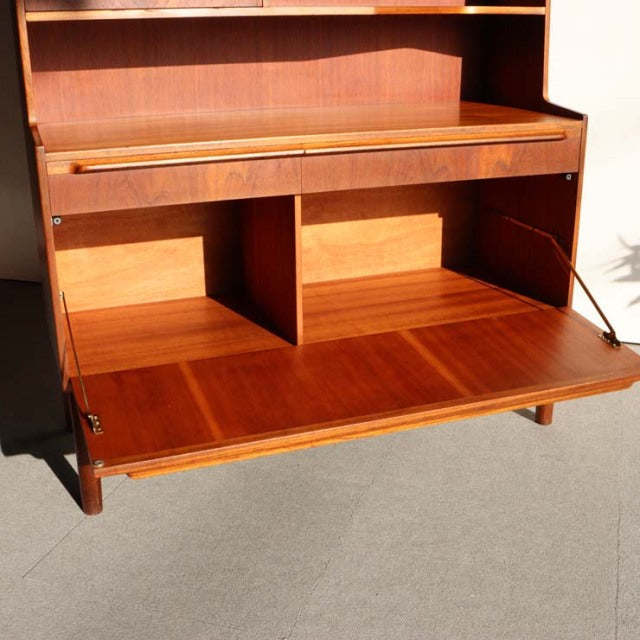 Vintage mid-century British teak cabinet by A.H. McIntosh with rich wood grain, tapered legs, and drop-down front panel.