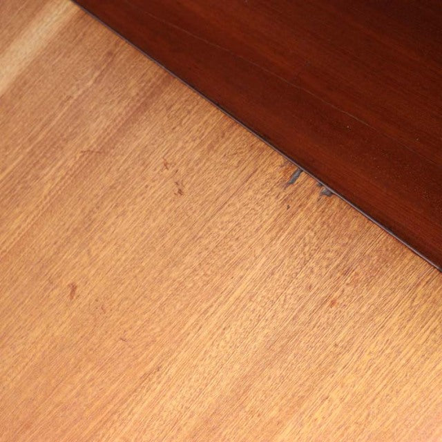 Close-up of vintage teak wood grain and smooth finish on British mid-century Macintosh cabinet surface.