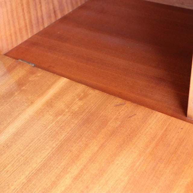 Close-up of vintage mid-century teak wood cabinet corner showing rich wood grain and smooth finish, British design by.