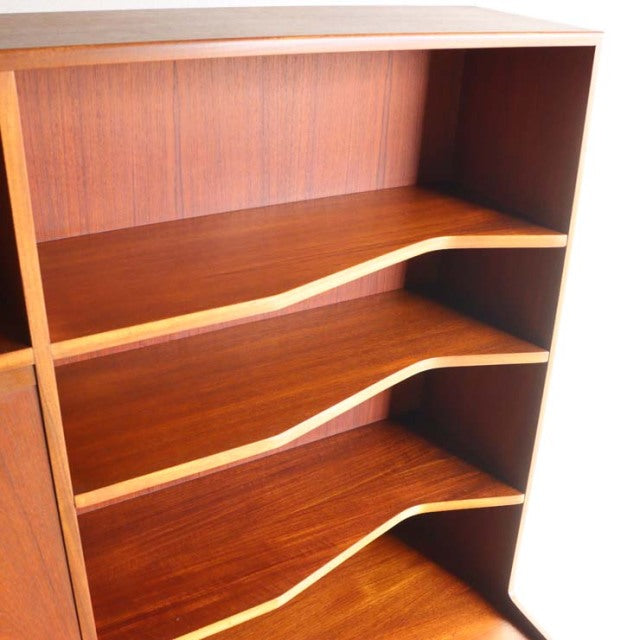 Vintage teak MacIntosh cabinet shelving with curved mid-century British design, smooth wood grain interior.