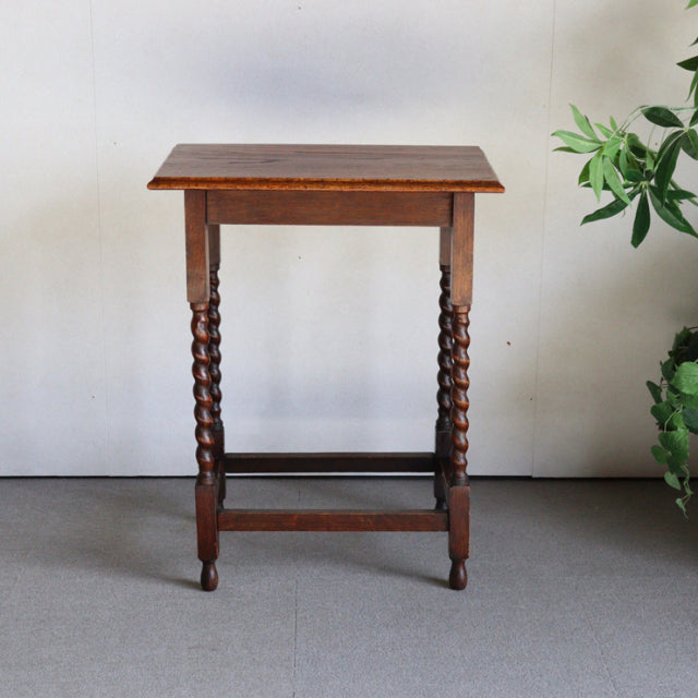 Vintage British mid-century teak side table with rich wood grain, barley twist legs, and stretcher base.