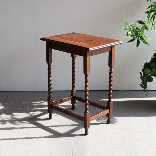 Vintage teak British side table with twisted mid-century legs and visible wood grain on top and frame.