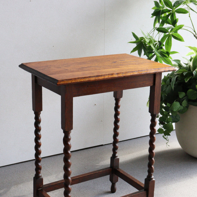 Vintage teak British mid-century side table with rich wood grain and twisted spindle legs in Denmark style.