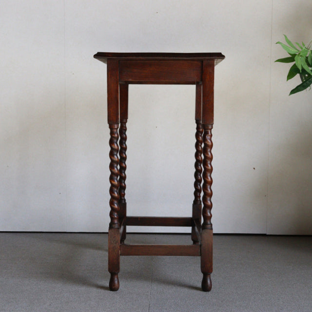 Vintage British teak side table with rich wood grain, mid-century style, and intricately turned barley twist legs.