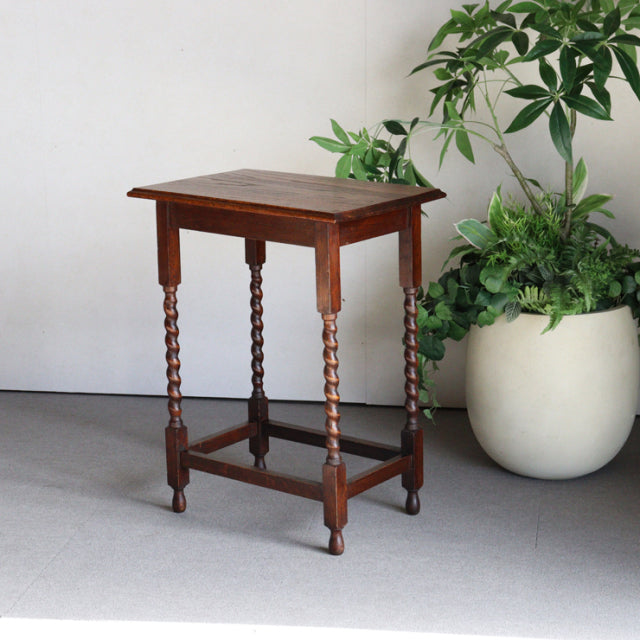 Vintage British mid-century oak side table with rich teak grain, barley twist legs, and stretcher base.