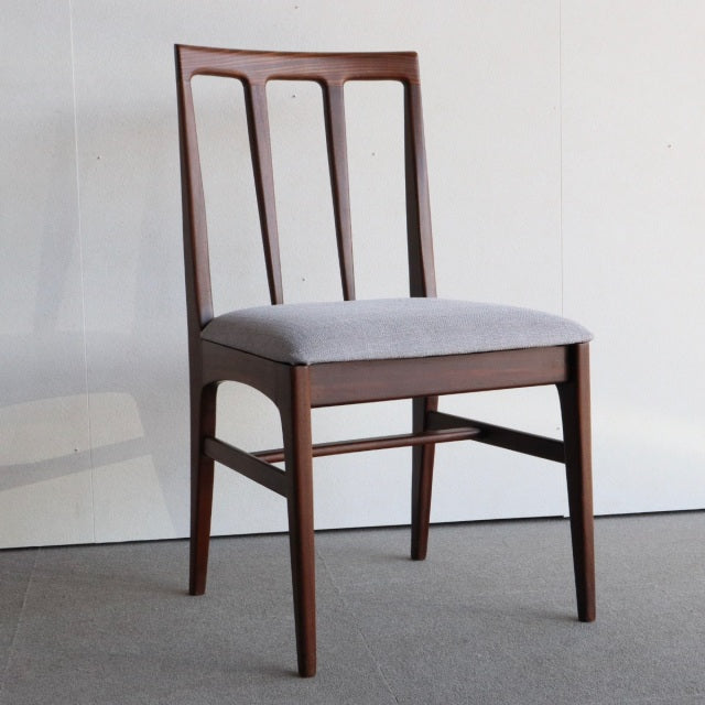Mid-century British Younger teak dining chair by John Herbert, gray upholstered seat, slim tapered legs, simple vertical.