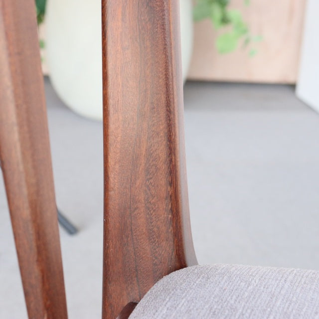 Mid-century British teak dining chair by Younger, curved wood grain backrest with light gray upholstered seat.