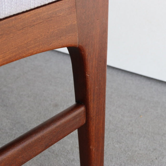 Close-up of vintage teak dining chair leg and frame with smooth wood grain, mid-century British design by Younger John.