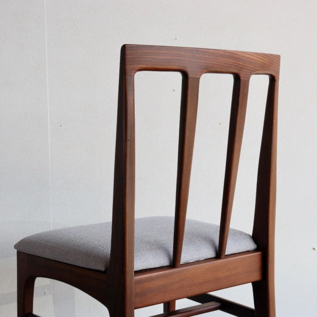 Mid-century British vintage teak dining chair by Younger with slatted back and gray upholstered seat.