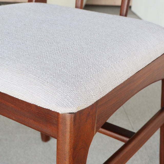 Close-up of vintage teak dining chair leg and frame by Younger, mid-century British design with textured light beige fabric.