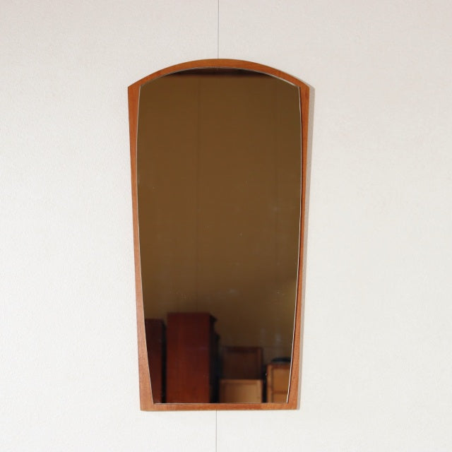 Vintage mid-century Danish teak wall mirror with arched top and visible rich wood grain.