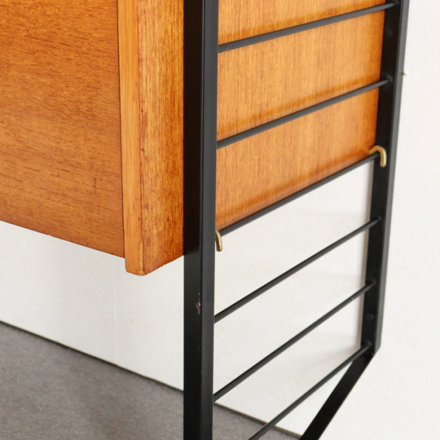 Vintage teak Ladderax shelving unit by Staples, British mid-century design with black metal frame and warm wood grain panels.