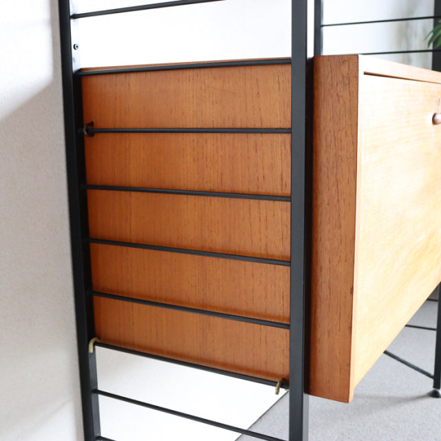 Vintage Ladderax shelving unit with teak wood panels, black metal frame, and mid-century British-Danish design.